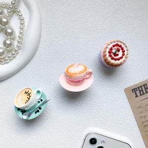 Three-piece miniature coffee and dessert phone grip set on textured background