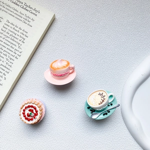 Detailed macro view of miniature resin pink cappuccino and strawberry cream tart models
