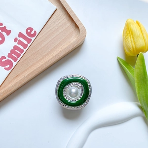 Close-up of pearl phone grip with green enamel finish and silver embossed metal details