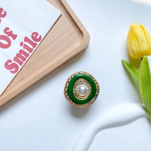 Detail of retro pearl phone grip with green enamel and gold rippled metal finish