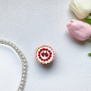 Detailed top view of a cute cupcake-shaped phone grip with red berries on white cream