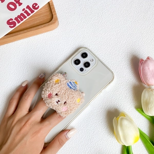 Macro shot of cute plush bear phone grip with embroidery on a clear iPhone case