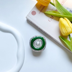 Macro view of retro round phone grip featuring white pearl and green enamel finish