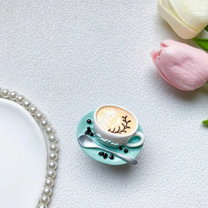 Macro detail of 3D coffee cup phone grip with latte art and miniature spoon