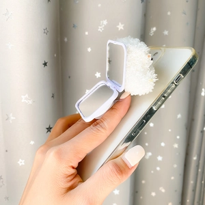 Detail of a plush white bear phone socket with a fold-out mirror held by a hand