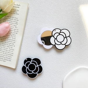 Detail of camellia flower folding phone mirror stand in black and white styles