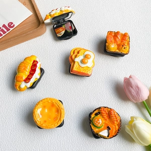 Flat lay of realistic food-shaped phone grips and mirrors like egg tart and croissant