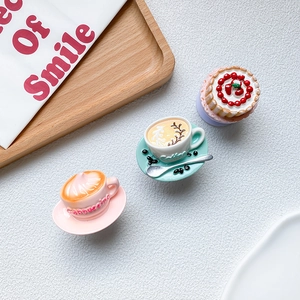 Miniature coffee and cake phone grip stand set on a white textured background