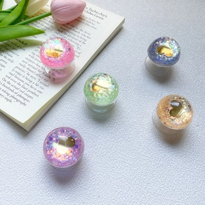 Close-up of heart-shaped glitter phone sockets in multiple pastel colors on a white desk