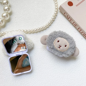 Detail of cute plush lamb portable makeup mirror with dual-sided glass and purple frame