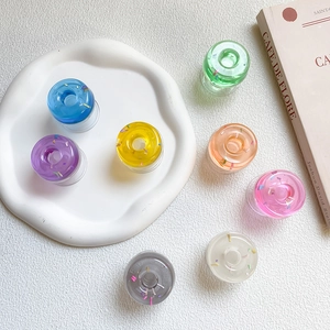 Macro view of seven colorful donut-shaped resin phone stands with glitter details