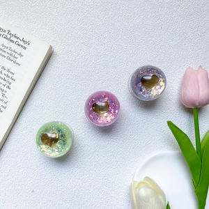Detail of glitter resin phone grips with gold hearts in pastel green, pink, and lilac
