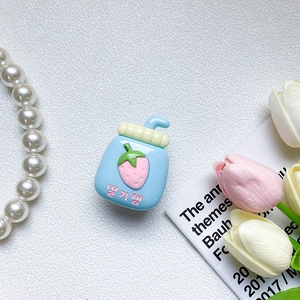 Close-up of cute strawberry milk bottle phone stand with floral and pearl decorative props