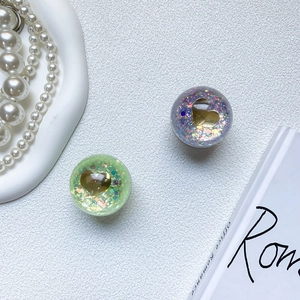 Detail of purple and green heart sequin phone grip holders on a white tray