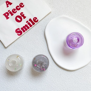 Detail of colorful resin donut phone grips with transparent purple and white glitter flakes