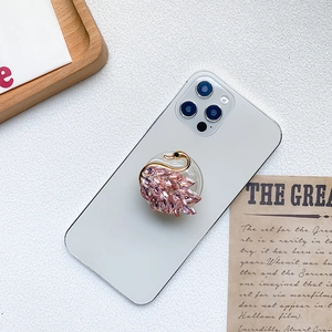 Luxury rhinestone swan phone socket grip with pink crystals on a white smartphone