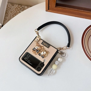 Detail of luxury Z Flip4 case with glitter finish, rhinestone bears and pearl chain