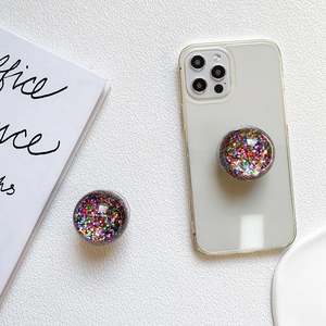 Close-up of a round phone grip with colorful sequins in a clear crystal ball design