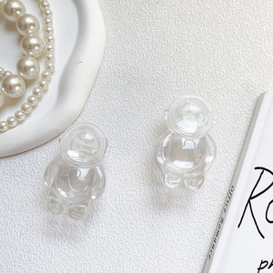 Macro detail of two transparent astronaut phone grips on a minimalist white textured surface