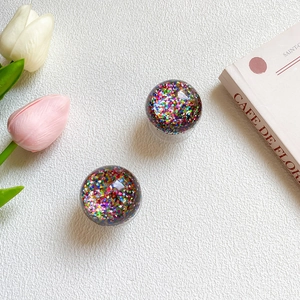 Detail of glitter-filled crystal ball phone grips with colorful sparkling sequins