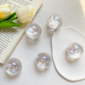 Detailed close-up of transparent heart phone grip with colorful sequins and aurora glitters