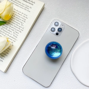 Detail of blue glitter phone grip with resin dome on grey backplate with flowers
