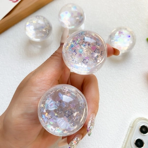 Macro shot of heart-shaped glitter and star sequins inside a clear resin phone socket