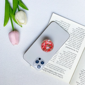 Detail of a resin phone grip with strawberry fruit slices on a smartphone back