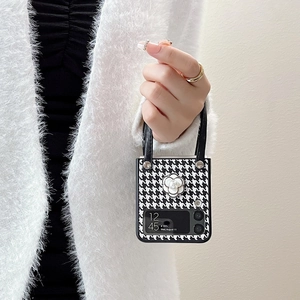 Detail showing the camellia flower and pearl charm on a houndstooth foldable phone case
