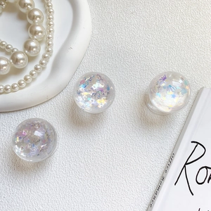 Macro detail of clear resin phone grips filled with iridescent star sequins on white background
