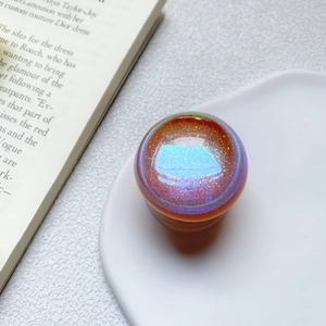 Detail of glittery laser phone grip on a white tray with an iridescent finish top