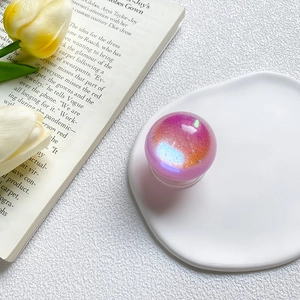 Macro view of holographic purple glitter phone socket on a white ceramic tray