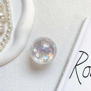 Detail of transparent phone socket with sparkling heart sequins and aurora glitter effect