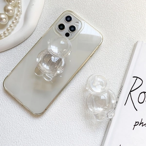 Transparent astronaut phone socket stand on clear case with modern aesthetic decor