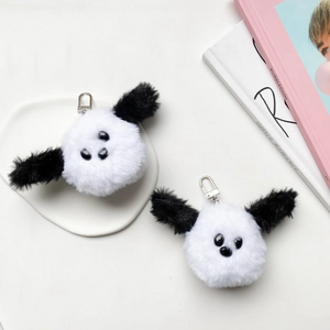 Detail of plush black and white puppy charms with soft fur texture and silver metal clips