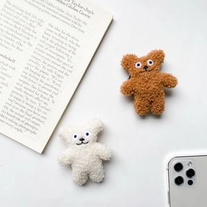Close-up of cute plush bear phone socket grip in brown and white sherpa material