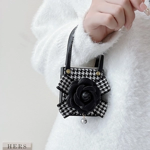 Detail of houndstooth mini bag charm with black leather rose and silver bead pendant