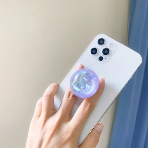 Close-up of a purple laser sequin crystal ball phone grip on a white smartphone