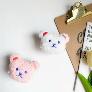 Macro detail of plush teddy bear mobile grips in pink and white curly lamb wool