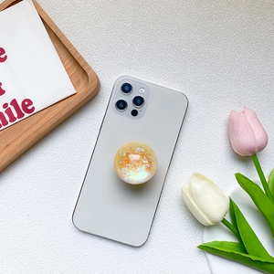 Laser glitter crystal ball phone grip with iridescent sequins on a white iPhone