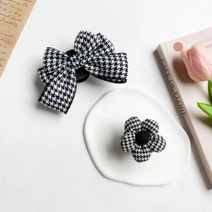 Close-up of black and white houndstooth fabric hair clips with bow and flower designs