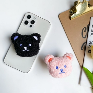 Close-up of cute plush bear phone socket with soft teddy fleece and detailed embroidery