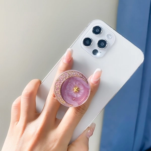 Purple glitter resin phone grip featuring a gold moon and star starship design on a smartphone