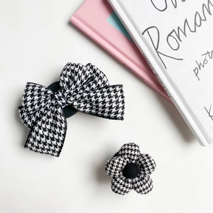 Detail of black and white houndstooth fabric hair clip set with flower and bow designs