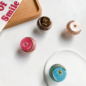 Close-up of star and moon resin phone grips with baroque gold details in four colors
