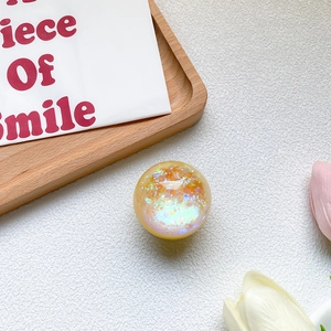 Close-up of holographic laser sequin crystal ball phone socket on a soft aesthetic background