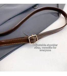 Detail of dark brown patent leather adjustable shoulder strap with golden metal buckle