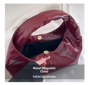 Detailed view of a dark red hobo bag showing its premium magnetic closure and texture