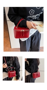 Detail showing red glossy patent leather box bag with gold-tone dual zipper and handle