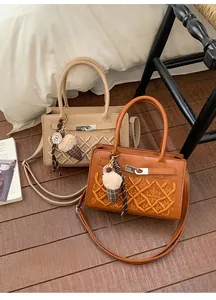 Detail of square crossbody bags in beige and brown with GA embroidery and ice cream charms